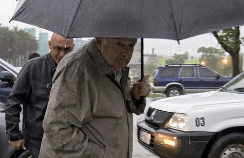 Pese al mal tiempo, José Mujica, actual presidente de Uruguay, fue uno de los primeros en votar esta mañana. (Foto: AFP)