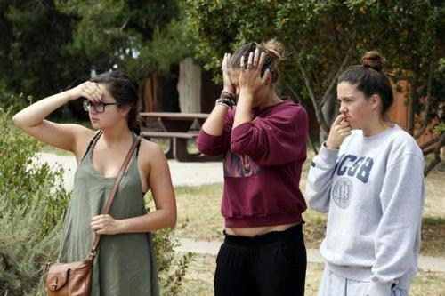 El tiroteo ocurrió la noche del viernes. En la foto algunas universitarias que observan lo sucedido después del crimen. 