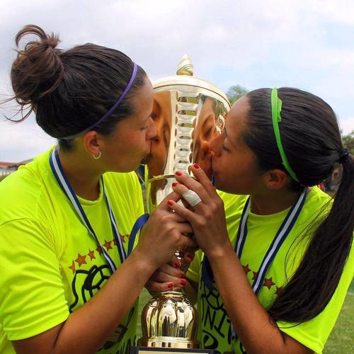 Coralia junto a su hermana María Amanda, a la izquierda, besa uno de los trofeos conseguidos cuando jugaba para Unifut de Guatemala. (Foto: Cortesía Coralia Monterroso)