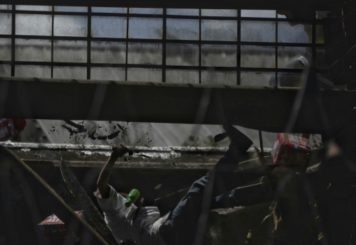 El momento exacto en el que uno de los reclusos cae del techo. (Foto: Wilder López/Soy502) 