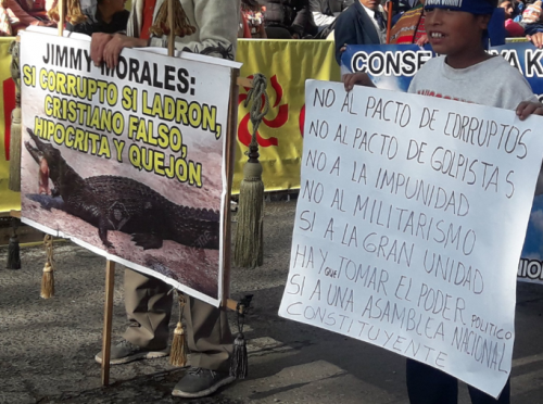 Un menor porta una pancarta en Quetzaltenango en rechazo a las acciones de Jimmy Morales. (Foto: Stereo100)