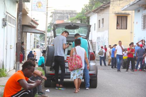 El pastor y algunos voluntarios llegan para repartir comida y café a los migrantes mientras esperan la apertura de la COMAR. (Foto: Fredy Hernández/Soy502)