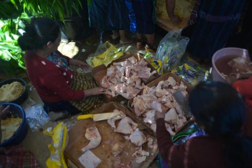 Las damas se reúnen para deshuesar los pollos que servirán para preparar los alimentos de los velorios. (Foto: Jesús Alfonso/Soy502)