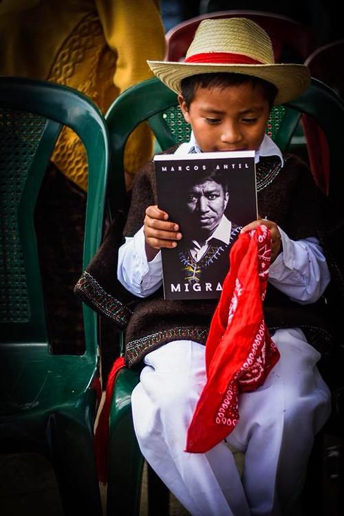 Un pequeño sostiene uno de los libros de la biografía de Mascos antil llamada "Migrantes". (Foto: marcos Antil)