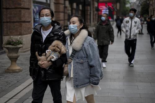 Una pareja sale a caminar por la ciudad de Wuhan, pero aún con temor de una nueva oleada de coronavirus. (Foto: AFP)