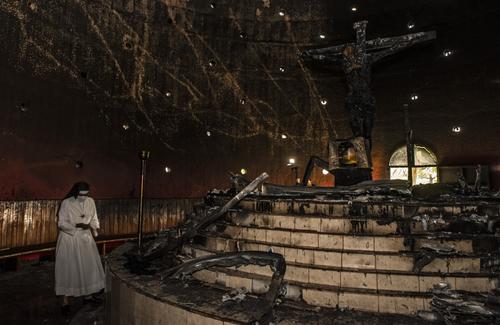 Una religiosa camina cerca del altar donde explotó la bomba que atentó con la histórica imagen. (Foto: AFP)