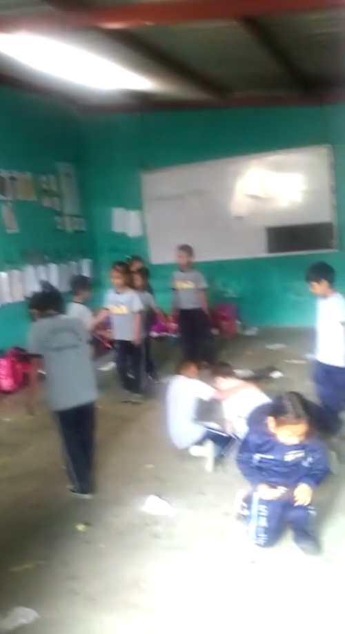 Los niños juegan en el aula de donde se sacaron los escritorios. (Foto: captura de pantalla) 