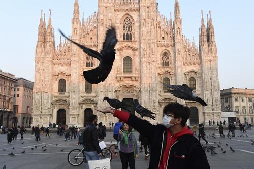 Un hombre sostiene unas palomas frente a la Piazza del Duomo, la plaza principal de Milán, Italia. (Foto: Miguel Medina /AFP) 