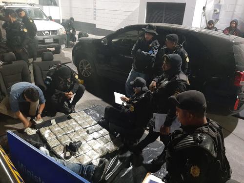 Agentes de la Unidad Antinarcótica realizan el chequeo del vehículo donde se encontró una fuerte suma de dinero. (Foto: PNC)