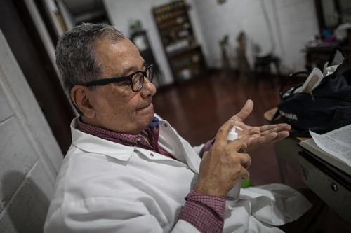El doctor se aplica gel antibacterial antes de iniciar las consultas médicas. (Foto: AFP)