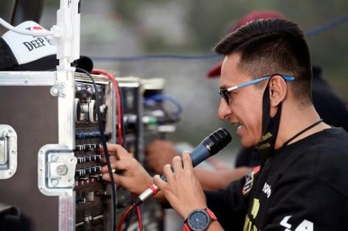 El DJ mexicano Roberto García prueba su micrófono antes de empezar su show en un tejado del barrio Río Hondo en Naucalpan de Juárez, México. (Alfredo Estrella/AFP) 