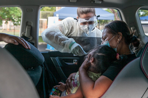 Una madre toma a su hija mientras toma una prueba por Covid-19.  (Foto: Cindy Karp/The Washington Post)