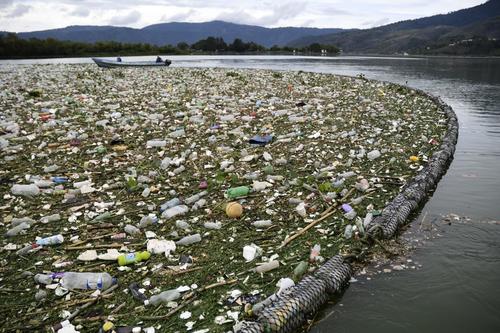 La basura es contenida en una barrera flotante para su extracción. (Foto: Johan Ordoñez/AFP(