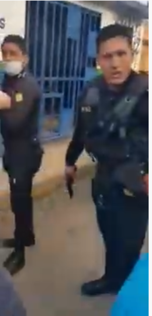 El agente de PNC después de realizar el disparo a los pies de las personas que se oponían a las capturas. (Foto: captura de pantalla) 