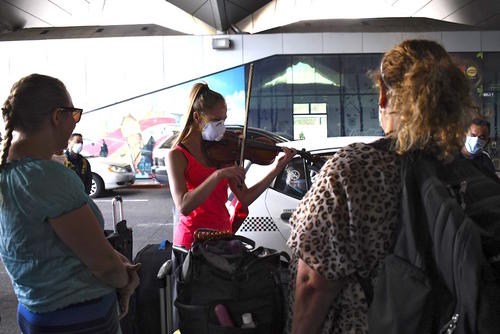 Violinista deleitó a ciudadanos estadounidenses que esperaban el vuelo que llevará de vuelta a casa en las afueras del aeropuerto La Aurora foto soy502 Guatemala