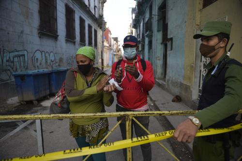 Un elemento policial vigila un puesto de control para evitar que las personas salgan del perímetro de cuarentena. (Foto: AFP)