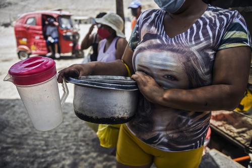 Las personas llegan con ollas y otros recipientes para llevar comida a sus hogares. (Foto: AFP)