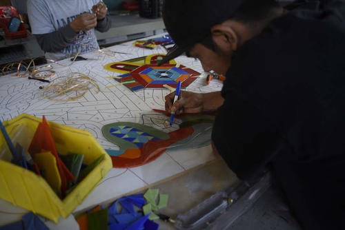 Amilcar y Rafael en el proceso de armar los vitrales, en base al mapa del artista Marlov Barrios. (Foto: Wilder López/Soy502)