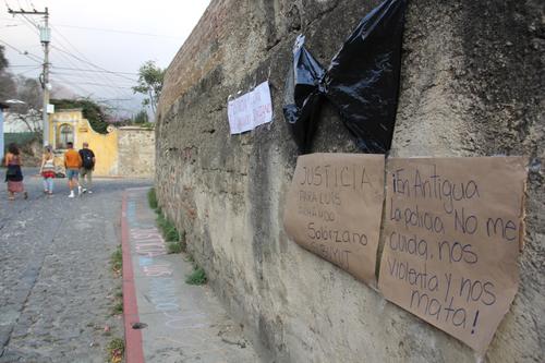 El cuerpo de Luis Armando Solórzano quedó tendido sobre la calle llamada La Cuesta del Chucho. Un día después se colocó una moña negra y letreros repudiando lo ocurrido. (Foto: Fredy Hernández/Soy502)
