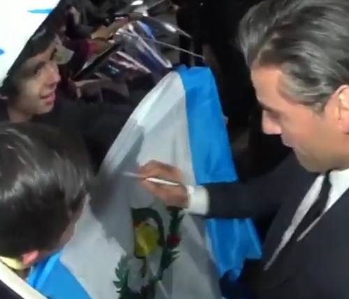 Oscar Isaac firmando una bandera de Guatemala en la premier de "Star Wars Episodio VII: El Despertar de la Fuerza”. (Foto: Captura de pantalla)