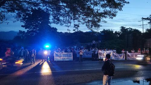 Ciudadanos con pancartas de "No más bloqueos" a las orillas del puente Castillo Armas, Retalhuleu. (Foto: Cortesía)