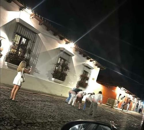 Hombres se bajan los pantalones para mostrar la parte trasera de su cuerpo en una fotografía en la Antigua. (Foto: redes sociales)