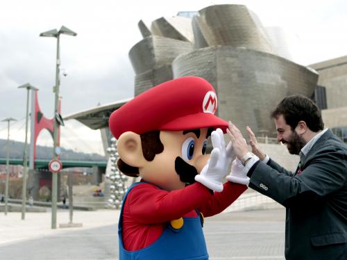 El personaje Super Mario junto al responsable de Nintendo en España, José Arcas, en el Museo Guggenheim tras la presentación del videojuego Super Mario 3D World en el marco del "Fun & Serious Games Festival". (EFE/ Luis Tejido)