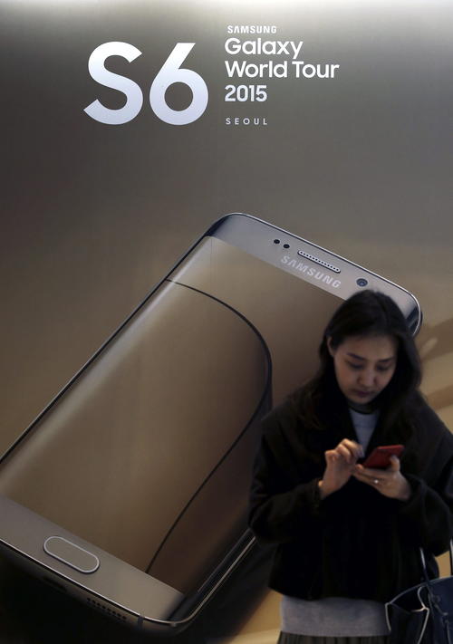 Una visitante utiliza su teléfono frente a un cartel publicitario de los nuevos teléfonos inteligentes Samsung Galaxy S6 y el Galaxy S6 Edge. (Foto:  EFE/Jeon Heon-Kyun)