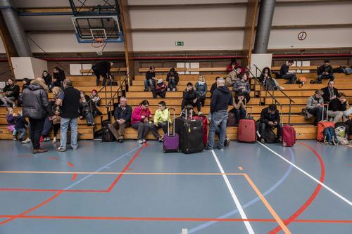 Varios pasajeros descansan en un polideportivo en Zaventem, cerca de Bruselas. (Foto: EFE)