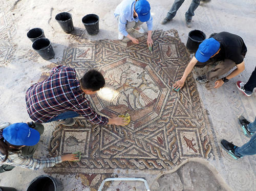 Arqueólogos realizan labores de limpieza del mosaico, previo a darlo a conocer a visitantes y residentes de la ciudad de Lod. (Foto: itongadol.com.ar)