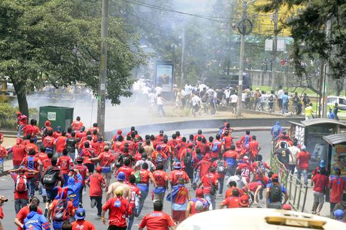 Aficionados rojos persiguen a los Cremas, en las afueras del estadio Manuel Carrera de El Trébol. (Foto: Nuestro Diario)