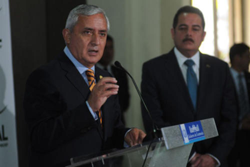 Otto Pérez recibe las regalías de Banrural de mano de Fernando Peña (al fondo). (Foto: Internet)