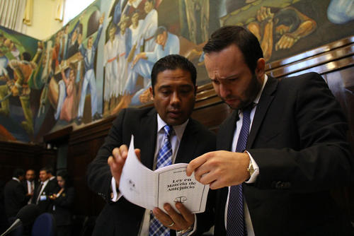Fernando García (I) y Hugo Morán, vocales I y III, respectivamente, de la Comisión Pesquisidora, revisan la Ley en Materia de Antejuicio, para determinar la legalidad del retiro de Baudilio Hichos. (Foto: Alexis Batres/Soy502)