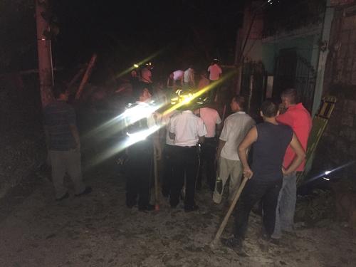 Bomberos y vecinos trabajan en el rescate de las personas que se encontraban en el interior de las 15 viviendas afectadas por el derrumbe en la aldea El Cambray II, Santa Catarina Pinula. (Foto: Bomberos Voluntarios)