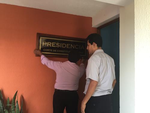 Empleados de la CC colocan el rótulo en las afueras de la oficina de Gloria Porras que ahora se identifica como la Presidencia. (Foto: Evelyn de León/Soy502) 