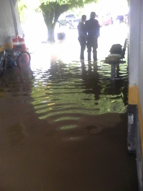Dos agentes de la PNC se encuentran en las afueras de la Comisaría de Izabal que se inundó por los malos drenajes. (Foto: PDH) 