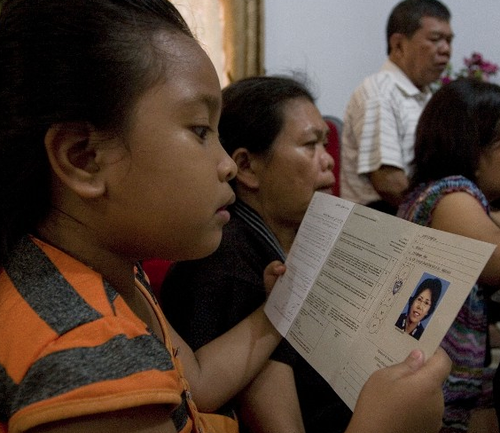 Esta niña observa los documentos de su tía Suri Dahlia quien viajaba en el vuelo desaparecido. (Foto:AFP)