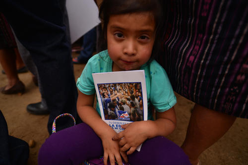 Entre los niños que estaban en el mitin fueron repartidos cuadernos con la imagen de Jimmy Morales. (Foto: Wilder López/Soy502)