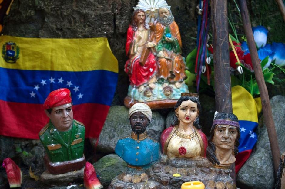 Sobresale la imagen de Hugo Chávez, acompañado de otras deidades que son veneradas durante un ritual de santería. (Foto: Federico Parra/AFP)
