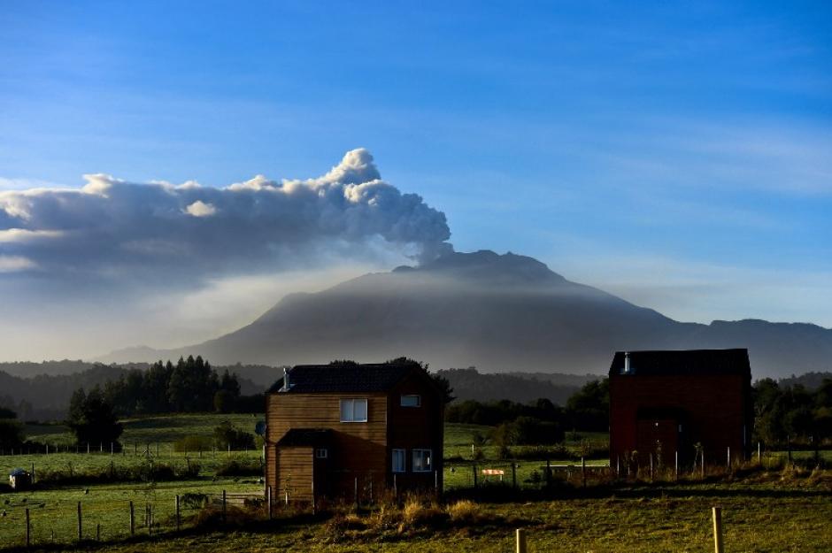 Muchos chilenos no perdieron la oportunidad de grabar la erupción del volcán Calbuco, que tiñó el cielo de gris y naranja ante su constante actividad. (Foto: AFP)&nbsp;