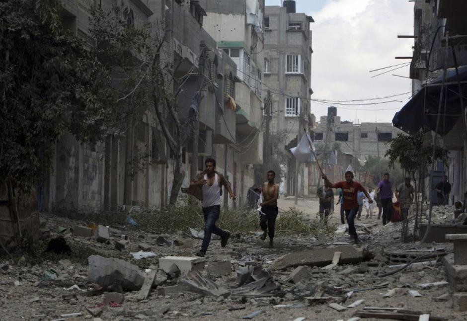 Civiles corren en las calles de Shejaiya en Gaza donde al menos 40 personas han mueret este domingo. (Foto: AFP)&nbsp;