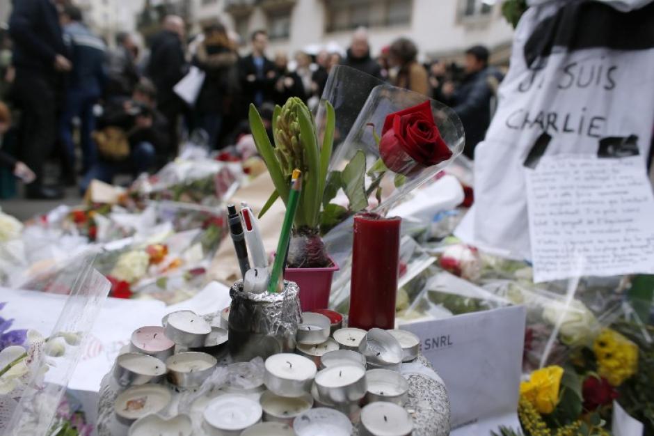 Decenas de personas se han acercado a las afueras de las oficinas de Charlie Hebdo para poner arreglos florales y candelas en memoria de las víctimas del atentado que cobró la vida de 12 personas a mitad de esta semana en París, Francia. (Foto: AFP)