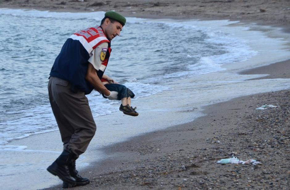 Un operario turco retira el cuerpo del menor de la costa. (Foto: AFP)