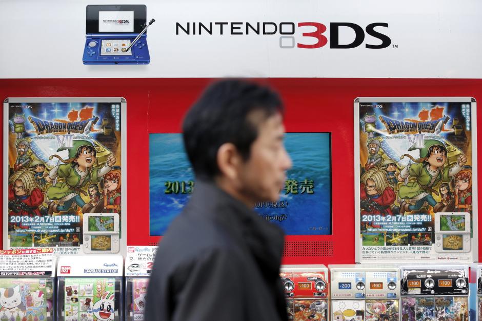 Un cliente pasa delante de una estantería con juegos para la videoconsola Nintendo 3DS en una tienda de electrónica de Tokio (Japón).