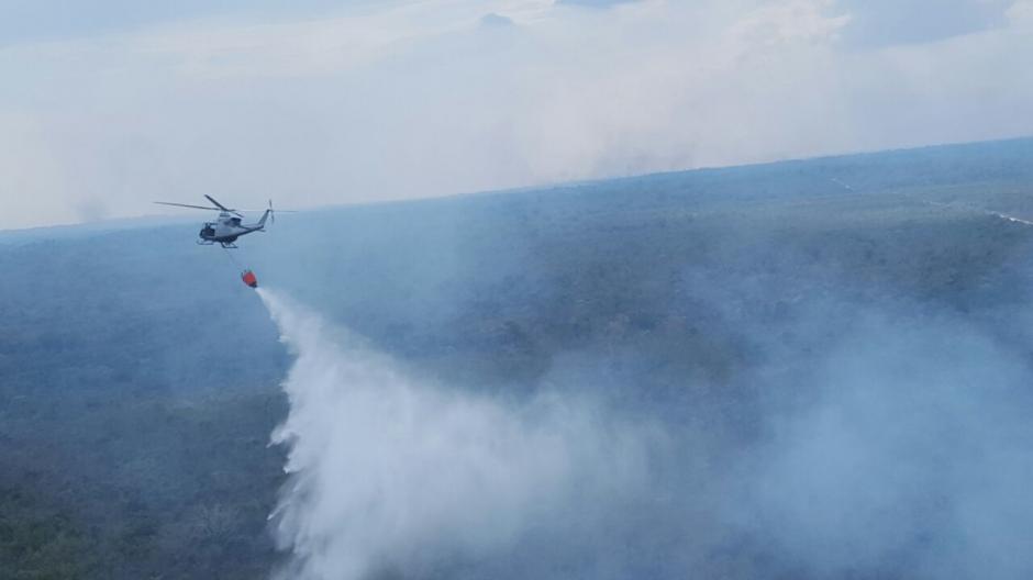 El helicóptero de Honduras realiza ocho descargas de agua por hora sobre los siete incendios en San Andrés, Petén. (Foto: Conap)