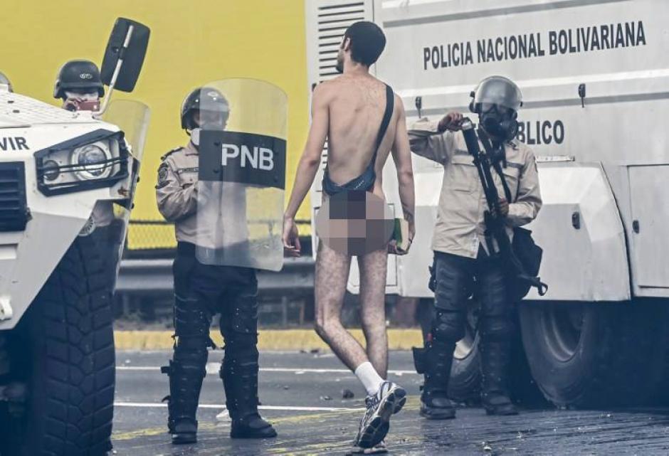 Como forma de protesta un opositor se desnudó frente a los agentes de seguridad del gobierno de Maduro. (Foto: AFP)