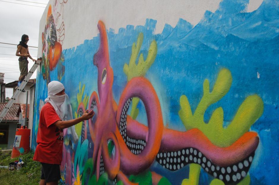 Un grupo de artistas pinta los muros debajo del puente de Río Dulce con el objetivo de convertirlo en un atractivo turístico para el lugar. (Foto: Fredy Hernández/Soy502)