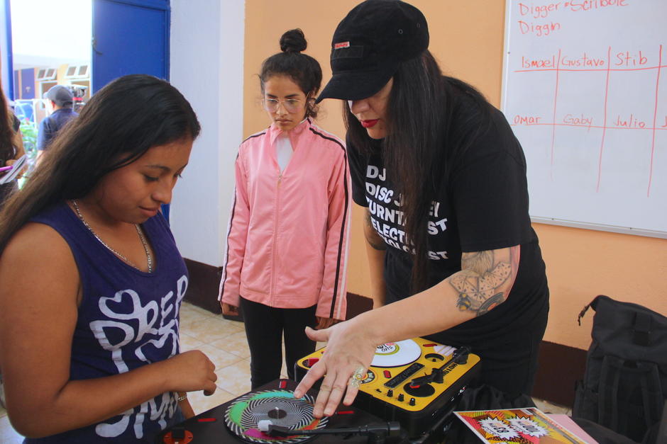 Dos chicas aprenden sobre las bases para convertirse en DJ. (Foto: Fredy Hernández/Soy502)