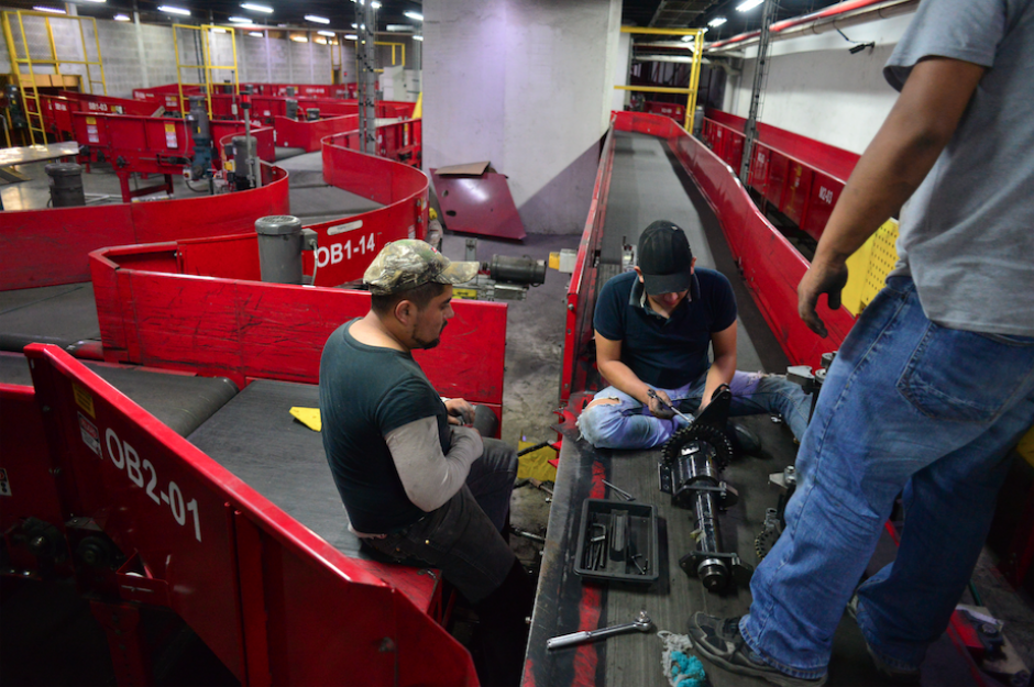 Trabajadores de la DGAC tratan de componer las cintas de equipaje que llevaban sin funcionar dos días. (Foto: Jesús Alfonso/Soy502)