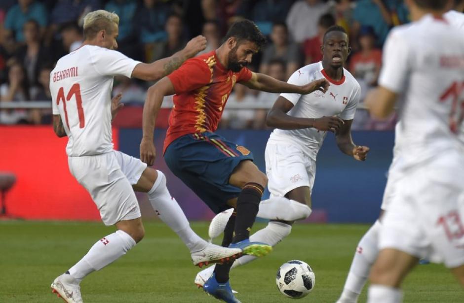 El español Diego Costa disputa el balón con dos marcadores suizos. (Foto: AFP)